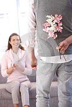 Young man bringing flowers to woman photo