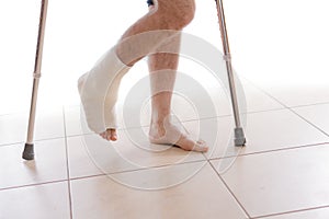 Young man with a broken ankle and a leg cast