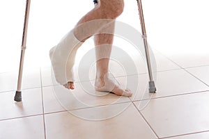 Young man with a broken ankle and a leg cast photo