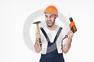 Young man builder holding drill and hammer