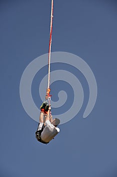 Young man bungee jumper hanging on a cord