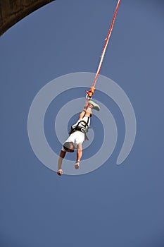 Young man bungee jumper hanging on a cord