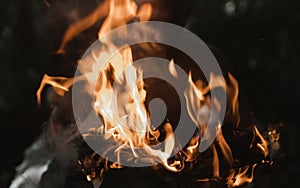 Young man with a burning match in the dark fire