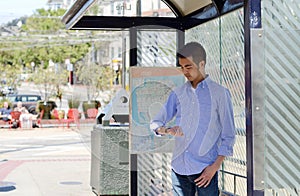 Young man at a bus stop