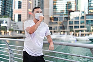 Young man in business district wearing black virus mask looking away. Copy space. Virus concept