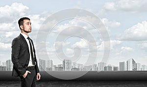 Young man in business suit, standing front of city landscape sunrise. Business, leadership and success concept