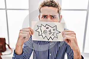 Young man business worker holding onomatopeia banner shouting at office