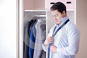 The young man businessman getting dressed for work