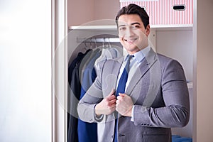 The young man businessman getting dressed for work