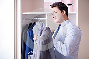 The young man businessman getting dressed for work