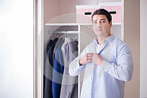 The young man businessman getting dressed for work