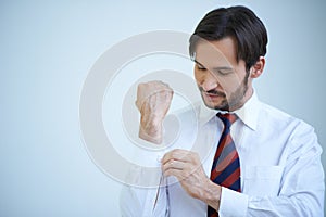 Young man buttoning his cuffs