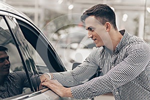 Young man buying new car at the dealership