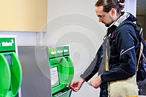 Young man buying train ticket
