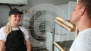 The young man buys bread in shop. Shopping supermarket. Smiling friendly bakery