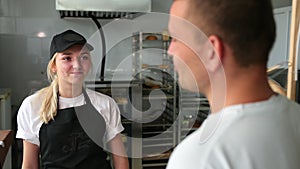 The young man buys bread in shop. Shopping supermarket. Smiling friendly bakery