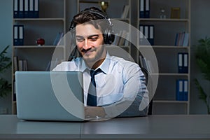 Young man in call center concept working late overtime in office