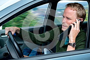 Young man is calling in the car