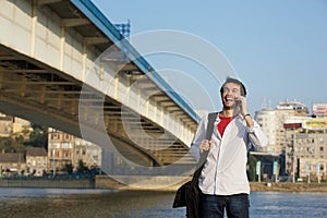 Young man calling by mobile phone outdoors