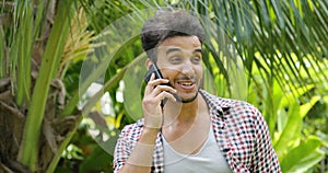Young Man Calling Using Cell Smart Phone Smiling Outdoors Mix Race Guy Closeup Speaking Over Green Trees