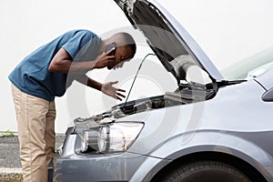 Young man calls for help with a stalled car