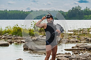 A young man in a calypso with a snorkel, mask and fins for snorkeling in the summer at the Rummu Quarry