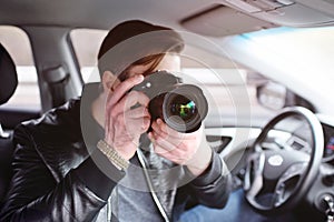 Young man with a camera in the car