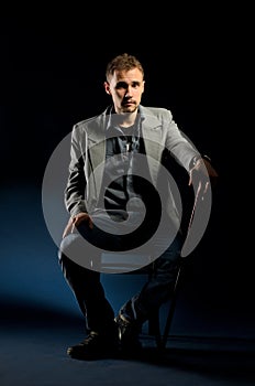 Young man with cane sitting on chair