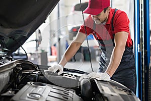 Young man car mechanic working in auto repair service