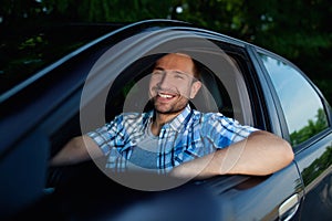 Young man in car smiling