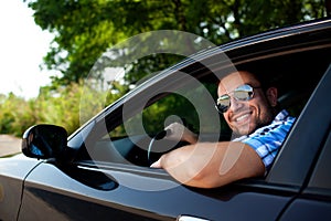 Young man in car smiling