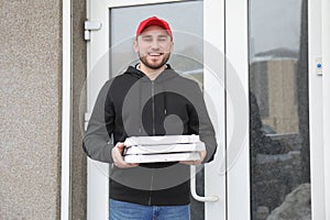 Young man with cardboard pizza boxes outdoors. Food delivery service