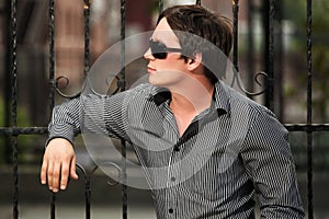 Young man at the cast iron fence