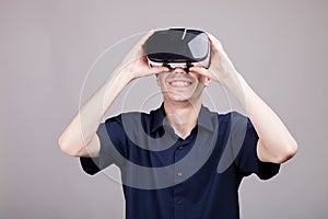 Young man in casual blue shirt wearing a VR virtual reality headset