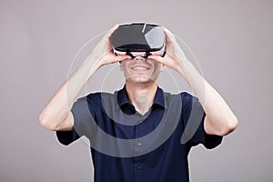 Young man in casual blue shirt wearing a VR virtual reality headset