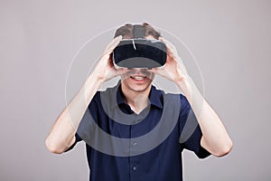 Young man in casual blue shirt wearing a VR virtual reality headset