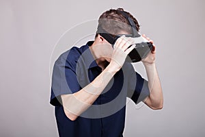 Young man in casual blue shirt wearing a VR virtual reality headset