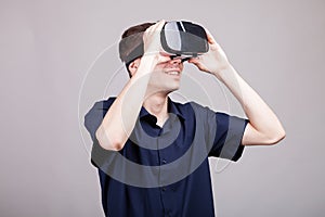 Young man in casual blue shirt wearing a VR virtual reality headset