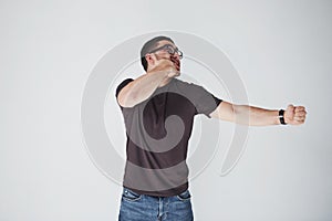A young man in casual clothes on the background struck himself on the fist in the face. The concept of self-punishment