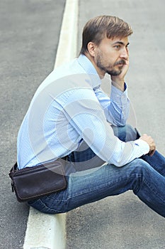 Young man in casual clothes with modern leather weist bag and sm