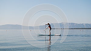 Young man in casual clothing paddling on sup board