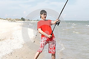 A young man catches a fish