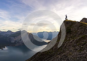 Young man celebrates reaching the peak of a mountain