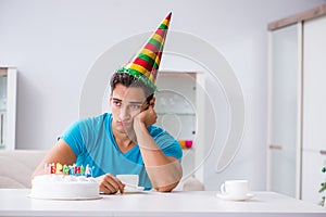 The young man celebrating birthday alone at home