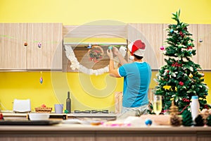 The young man celebrating christmas in kitchen