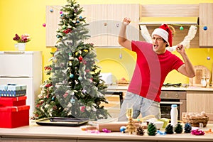 The young man celebrating christmas in kitchen