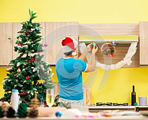 Young man celebrating Christmas in kitchen