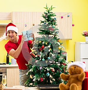 Young man celebrating Christmas in kitchen