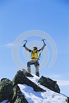 Young man celebrating reaching the top of mountain