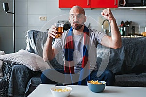 Young man celebrating and watching sports on the sofa